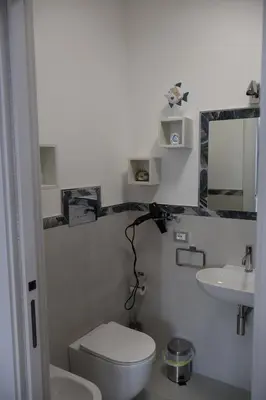 a white bathroom with a toilet and a sink at Verdemare in Macari