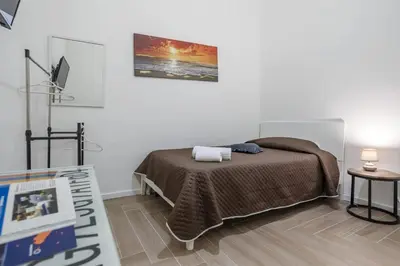 a bedroom with a bed and a tv and a table at L'Incanto centrale in Palermo
