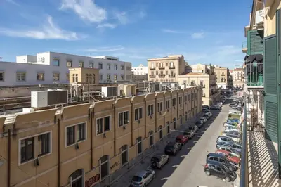 a city street with cars parked in a parking lot at L'Incanto centrale in Palermo