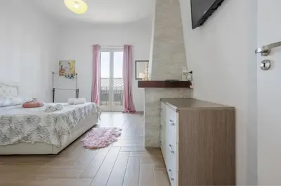 a white bedroom with a bed and a fireplace at L'Incanto centrale in Palermo