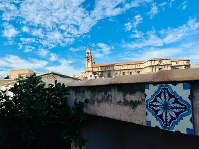 a building with a clock tower in the background at Terrazza Rosa Bianca in Palermo
