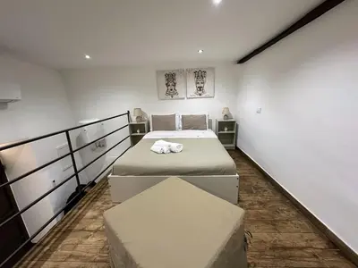 a small bedroom with two beds and a table at Mafone Home in Palermo