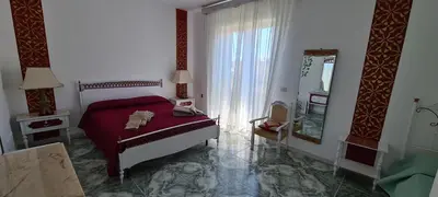 a bedroom with a red bed and a mirror at I Sollazzi in Palermo