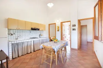 a kitchen with a table and chairs in a kitchen at sicilian rustic in Scopello