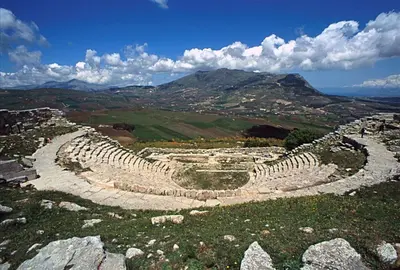 an amphitheater on a hill with mountains in the background at sicilian rustic in Scopello
