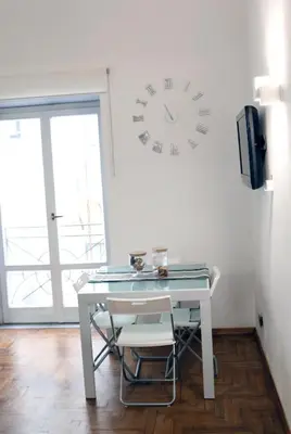 a white desk with a clock on a wall at Historic Centre - Apartment at Foro Borbonico in Palermo