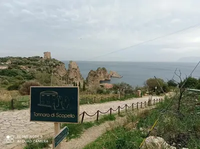 a sign on the side of a road next to the ocean at A'nicaredda (la piccolina) in Castellammare del Golfo