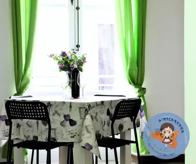 a table with green curtains and a vase of flowers at A'nicaredda (la piccolina) in Castellammare del Golfo