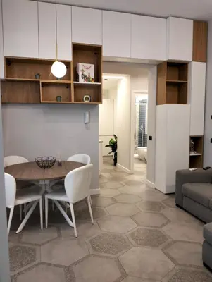 a dining room and living room with a table and chairs at Al Massimo apartment in Palermo