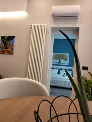 a dining room with a table and a bedroom at Al Massimo apartment in Palermo