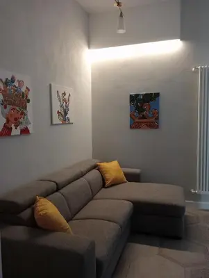 a living room with a couch and some paintings at Al Massimo apartment in Palermo