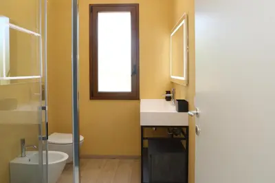 a bathroom with a sink and a toilet and a window at Villa Memi in Cefalù