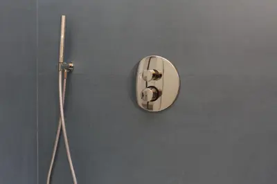 a round mirror on a wall next to a shower at Villa Memi in Cefalù