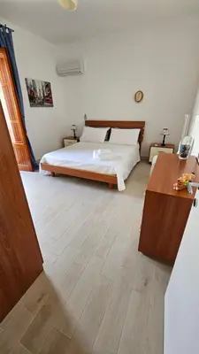 a bedroom with a bed and a wooden floor at IsolaHome in Isola delle Femmine