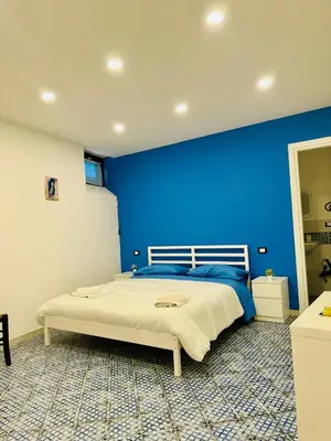 a blue bedroom with a bed with a blue wall at Corleone Home in Corleone
