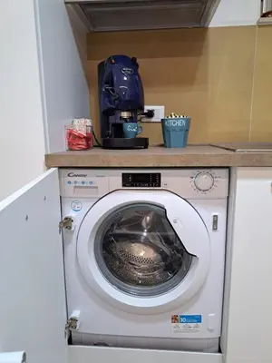 a washing machine in a kitchen with a helmet on top at Futtitinni Home casamia in Palermo