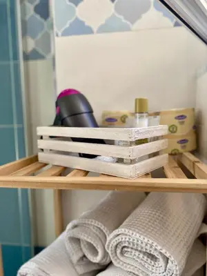 a wooden shelf with towels and other items in a bathroom at A casa di Alex in Palermo
