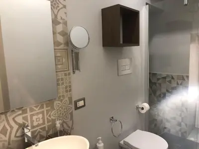 a bathroom with a toilet and a sink and a mirror at City Center Apartment da FeLù in Palermo