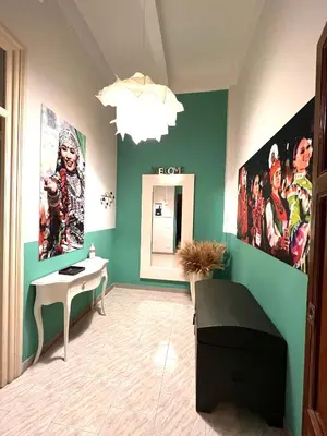 a room with green walls with a desk and posters at 