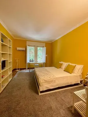 a bedroom with a large bed and a yellow wall at MATTI X 2 in Palermo