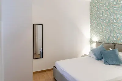 a bedroom with a white bed and a mirror at Four Luxury Apartment in Palermo