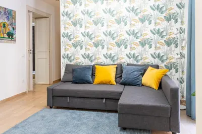 a living room with a gray couch with yellow pillows at Four Luxury Apartment in Palermo