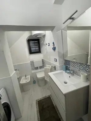 a white bathroom with a sink and a toilet at Tampasiando in Cinisi