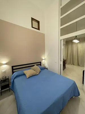 a bedroom with a blue bed in a room at Civico 356 in Castellammare del Golfo
