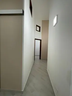 an empty hallway with white walls and wood floors at Civico 356 in Castellammare del Golfo