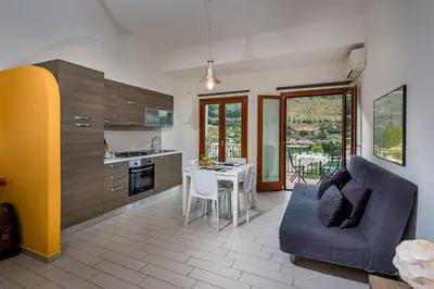 a kitchen and living room with a couch and a table at Veranda sul Porticciolo in Castellammare del Golfo