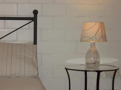 a glass lamp on a table next to a bed at Veranda sul Porticciolo in Castellammare del Golfo