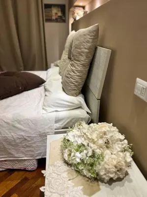 a table with a bouquet of flowers next to a bed at DEMMA LUXURY HOME in Palermo