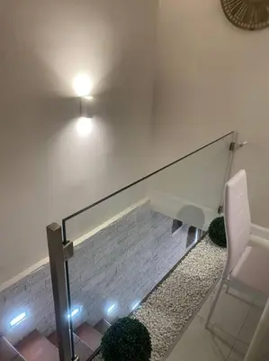 a staircase with a glass railing and a chair at DEMMA LUXURY HOME in Palermo