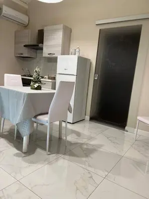 a kitchen with a table and chairs and a refrigerator at DEMMA LUXURY HOME in Palermo