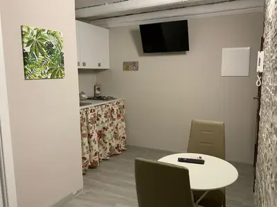a room with a table and chairs and a kitchen at Demma' s DIAMOND in Palermo