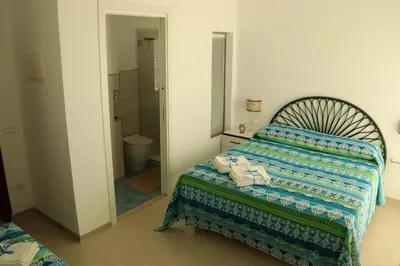 a bedroom with a bed and a bathroom with a toilet at Pensiero Speciale in Alcamo