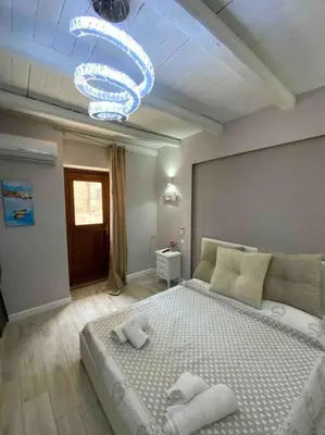 a bedroom with a large bed and a chandelier at Spasimo Boutique in Palermo