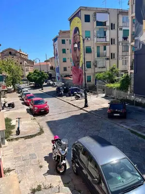 a motorcycle parked next to a car on a city street at Spasimo Boutique in Palermo