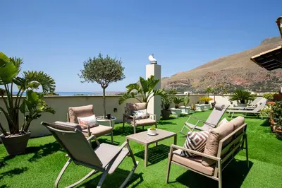 a patio with chairs and a table on grass at B&B L'Angolino della nonna in Castelluzzo