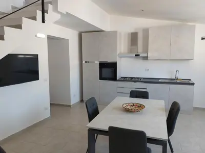 a kitchen and dining room with a table and chairs at Levante in Terrasini