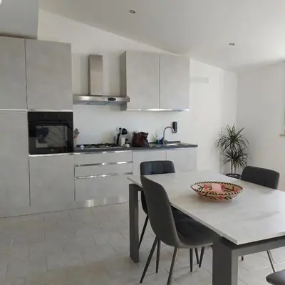 a kitchen with a table and chairs in a room at Levante in Terrasini