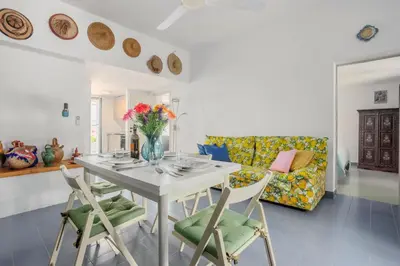 a living room with a table and chairs and a couch at Isulidda Gaia Mare in San Vito lo Capo