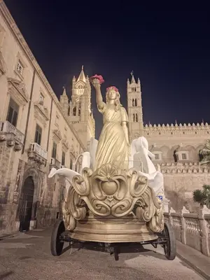 a statue of a woman sitting on a cart in front of a building at Le Due Perle in Palermo