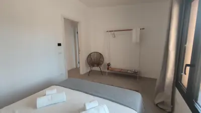 a bedroom with a bed and a chair in it at Casa di Pino in Cefalù