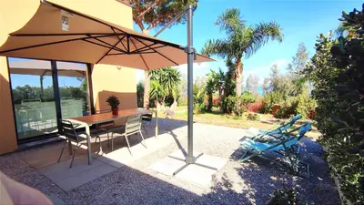 a patio with an umbrella and a table and chairs at Casa di Pino in Cefalù