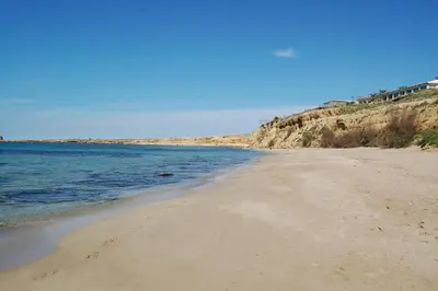 a sandy beach next to the ocean on a clear day at Cinisi 89 B&B in Cinisi