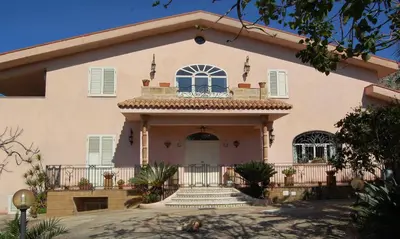 a large pink house with a balcony at Cinisi 89 B&B in Cinisi