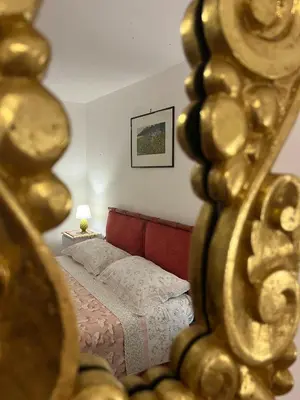 a reflection of a bedroom with a bed in a mirror at Casetta di Ale al Capo in Palermo