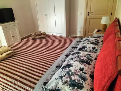 a bedroom with a large bed with a striped blanket at Casetta di Ale al Capo in Palermo