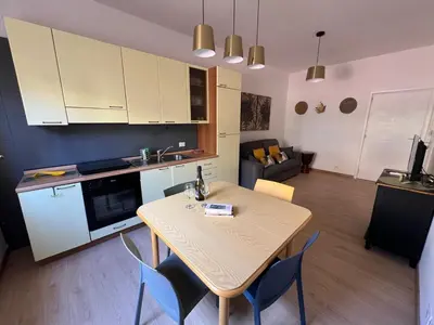 a kitchen and living room with a table and chairs at casa vacanze Mondello mare piscina CHIFEVI in Mondello